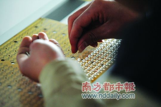 工人忙著安裝用于燈具發(fā)光的LED燈珠，這類工作處于LED燈具生產(chǎn)的最下游。資料圖